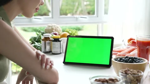 Professional Nutritionist checking data from a tablet with green screen Stock Footage 241758303