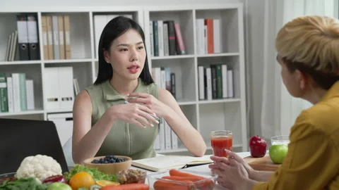 Professional Nutritionist explaining the data on the phone to her client Stock Footage 241758688