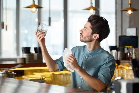 Professional Occupation. Bartender standing at counter looking at glass clarity Stock Photos