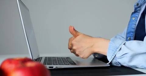 Professional office worker typing on laptop, displaying confident thumbs up Stock Footage 316757057