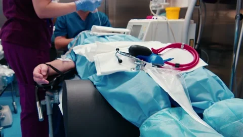 Professional ophthalmologist doing eye surgery in the operating room with nurse Stockbeeldmateriaal 229642994
