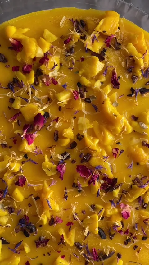 Professional overhead shot of mango tart with flowers and edible decorations Stock Footage 335366080