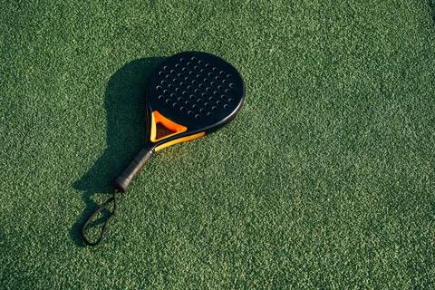 Professional Padel Racket Lying on Green Artificial Turf Under Sunlight Photos