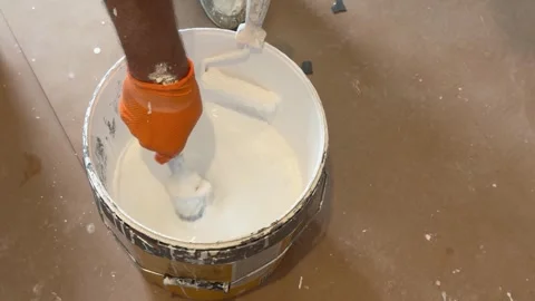 Professional painter dipping a brush into a bucket of white paint Stock-Footage 341363294