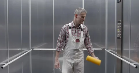 Professional painter taking the elevator Stock Footage 308916325