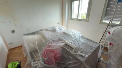 Professional painter taping and covering furniture before painting house interio Stock Footage 341363400