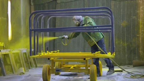 Professional Painter Uses Yellow Paint Sprayer in Industrial Paint Room Wide Stock Footage 136715522