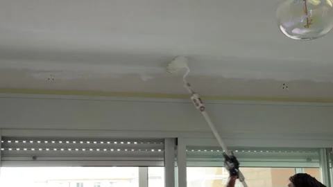 Professional painter using a paint roller on a white ceiling Vidéo 341362973