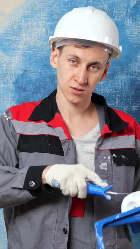Professional painter wearing a hard hat and uniform talking to camera and 库存影片 343908667