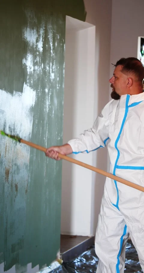 Professional Painter Wearing A White Protective Suit Paints An Interior Wal.. 库存影片 345090842