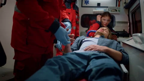 Professional paramedics checking oxygen blood level of victim Stock Footage 166906228