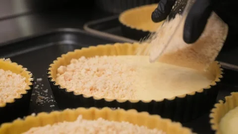 Professional Pastry Chef Adding Crumble Topping to Fresh Dessert Tarts – 4K Stock Footage 337751448