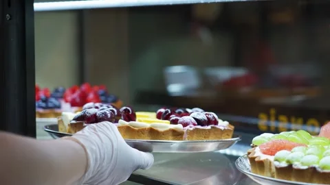 Professional Pastry Chef Arranging Fresh Fruit Tarts in Bakery Display Case 動画素材 337751213