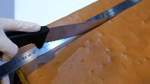 Professional Pastry Chef Cutting Large Sheet of Homemade Salted Caramel with Rul Stock Footage 331779850