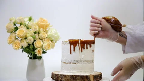 Professional pastry chef decorates the cake with caramel icing Stock Footage 149840261