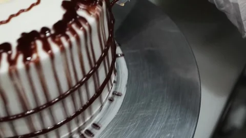 Professional Pastry Chef Decorating Chocolate Drip Cake on Rotating Stand Stock Footage 331777588