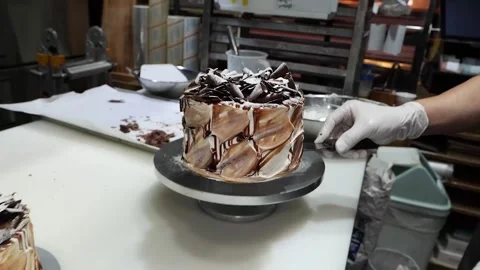 Professional Pastry Chef Decorating a Decadent Chocolate Layer Cake with Shards Stock Footage 331777651