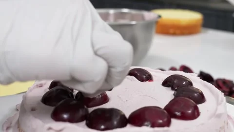 Professional Pastry Chef Decorating Layered Cake with Fresh Dark Cherries Stock Footage 343020694