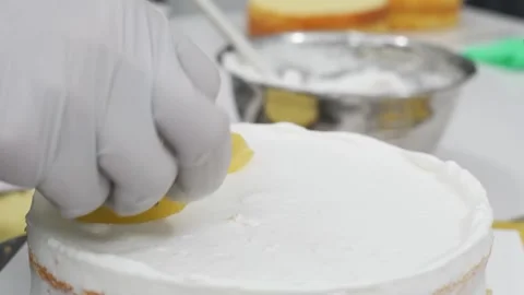 Professional Pastry Chef Decorating White Cream Cake with Fresh Yellow Kiwi Slic Stock Footage 343020588