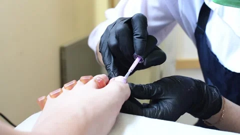 Professional pedicure master polishing nails with shellac, pink color pedicure Stock Footage 242012386