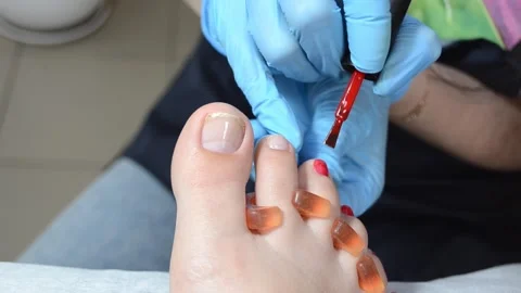Professional pedicure master polishing nails with shellac, red color pedicure , Stock Footage 249556050