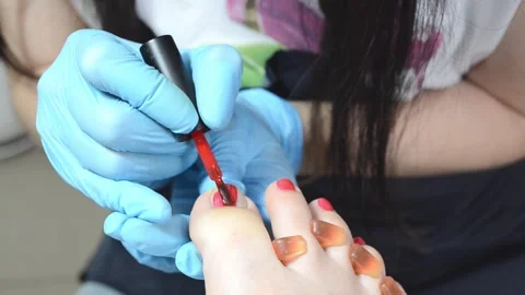Professional pedicure master polishing nails with shellac, red color pedicure , Stock Footage 249556064