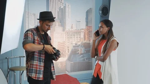 Professional photographer asking model to stop talking on smartphone and Stock Footage 122578584