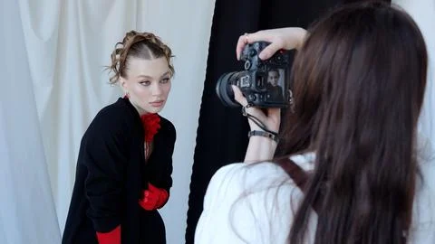 Professional photographer using digital camera while shooting fashion model Stock Photos