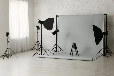 Professional photography studio setup with gray backdrop, lighting equipment, Stock Photos