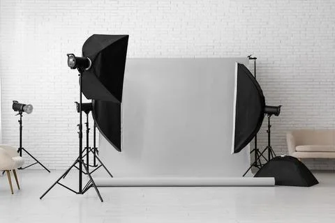 Professional photography studio setup with softboxes, strobe lights, and gray Stock Photos