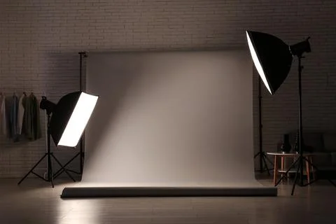 Professional photography studio setup with white backdrop and lighting equipm Stock Photos