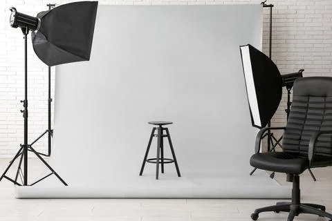 Professional photography studio setup with white background, stool, office ch Stock Photos
