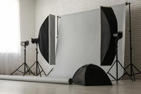Professional photography studio setup with white brick wall, gray background  Stock Photos