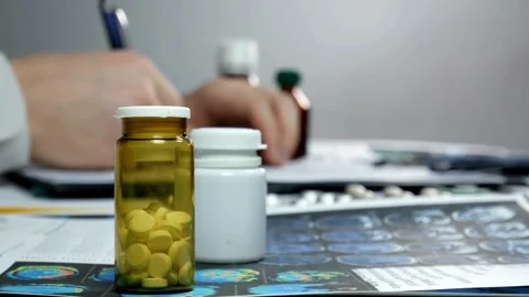 Professional physician gp wearing white coat writing notes using a pen at Stock-Footage 336587803
