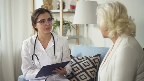 Professional physician talking with aged ill lady Stock Footage 103715663