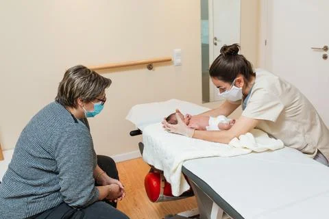 Professional physiotherapist doing an extensor tone relaxation on a newborn baby Stock Photos