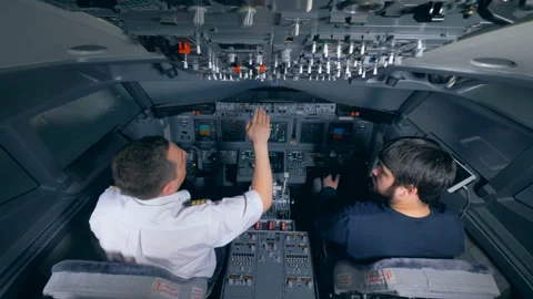 Professional pilot is instructing a man in a flight simulator Stock Footage 90749606