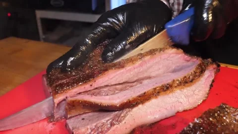 Professional Pitmaster Slicing Juicy Texas-Style Smoked Beef Brisket on Cutting Stock Footage 338212591