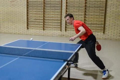 Professional player does a forehand top-spin during training on a blue tabl.. Stock Photos