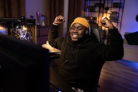 A professional player with a headset playing and winning a video game on his Stock-Fotos