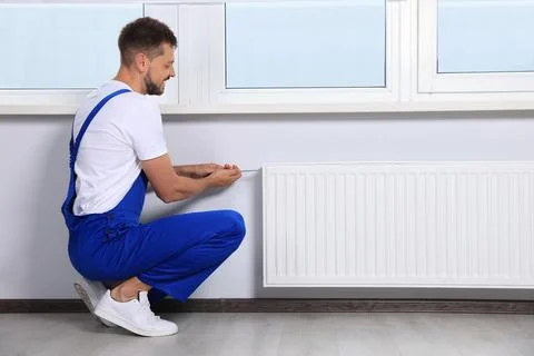 Professional plumber using screwdriver while preparing heating radiator for.. Stock Photos