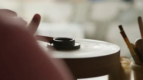 A professional potter makes a lid for a clay teapot on a potter's wheel Stock Footage 145534568