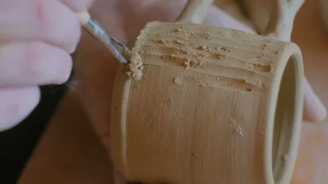 Professional potter making pattern on clay mug with special tool in workshop Stock Footage 100082738
