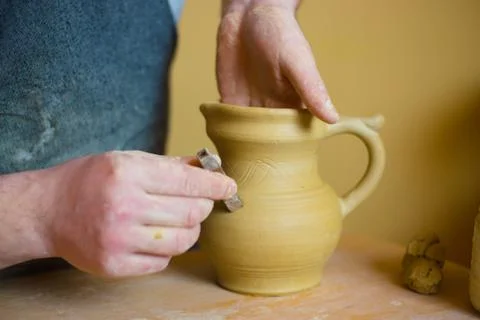 Professional potter making pattern on clay jar with special tool in pottery Stock Photos