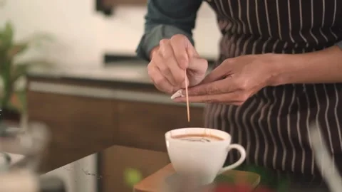 Professional pouring stream milk to create a latte art pattern in white cup. 動画素材 334650273
