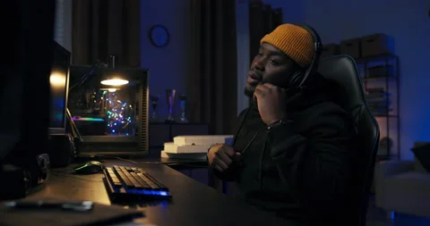 A professional programmer sits late into the night at a lit computer, writing Stock Footage 178548134