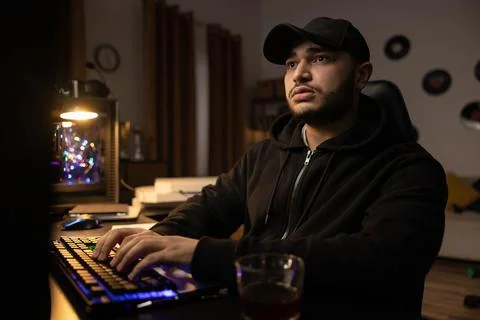 A professional programmer sits late at night at a computer with a light on Stock-Fotos
