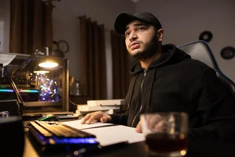 A professional programmer sits late at night at a computer with a light on Stock Photos