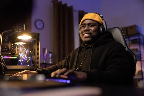 A professional programmer sits late at night at a lit computer, writing software Foto stock