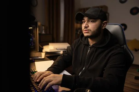A professional programmer sits late at night at a computer with a light on Stock Photos